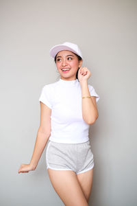 Portrait of smiling girl standing against white background