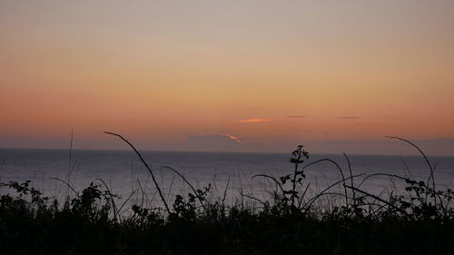 Scenic view of sea against romantic sky at sunset