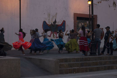 Group of people dancing against wall in city