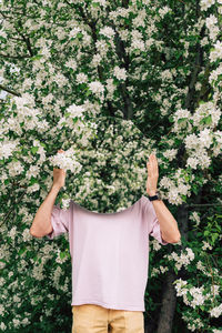 Rear view of woman standing amidst plants