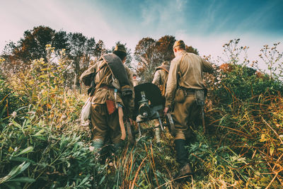 Rear view of army soldiers walking in forest