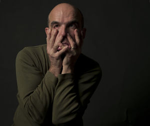 Portrait of man against black background