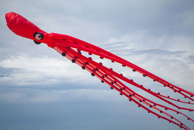 Low angle view of red flag against sky