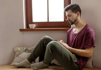 Man using mobile phone while sitting at home