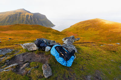 Two hiking backpacks on mountain with scenic view of coast and sea in moskenesoya lofoten norway