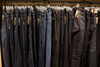 Various jeans hanging on clothes rack in store