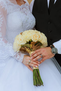 Close-up of couple holding bouquet