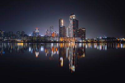 Reflection of illuminated buildings in city at night