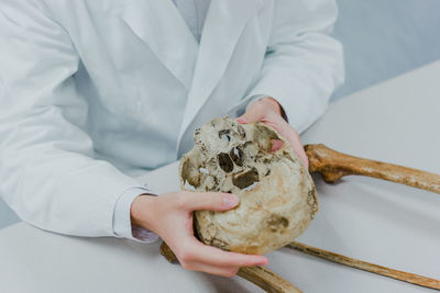 Human skull in handwith bones around and studying medic