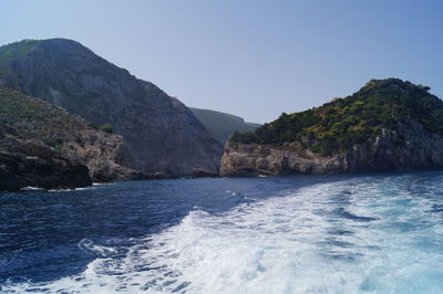 Scenic view of sea and mountains against clear sky