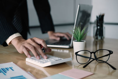 Midsection of businessman working on table