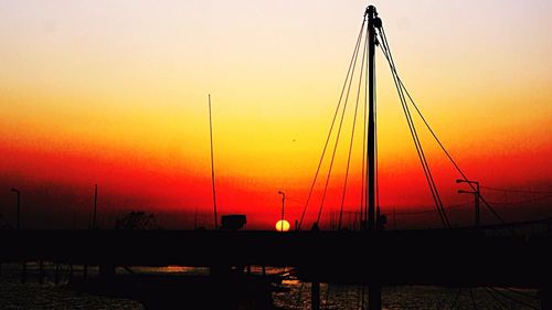 Sailboats in sea at sunset