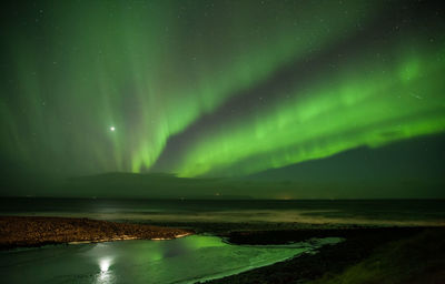 Scenic view of lake against sky at night