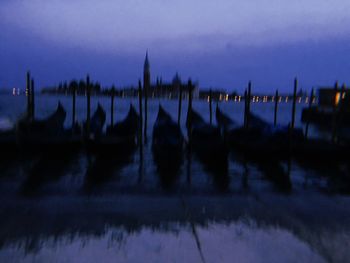 Panoramic view of wooden posts in water at night