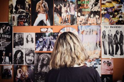 Rear view of woman standing against graffiti wall