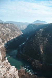 Scenic view of river and mountains against sky