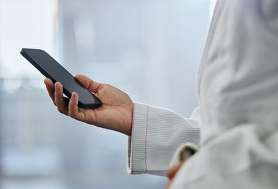 Midsection of man using mobile phone