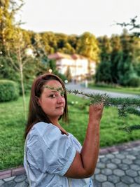 Portrait of smiling woman standing against plants