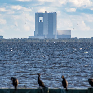 View of buildings by sea against sky