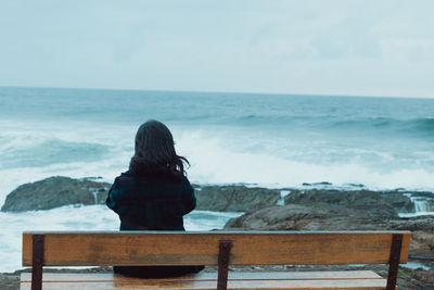 Rear view of woman looking at sea against sky