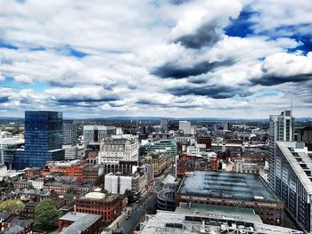 High angle view of city buildings against cloudy sky