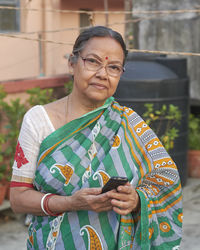 Portrait of smiling young woman using mobile phone