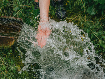 Stream of pure spring water. human hand in crystal clear cool spring.