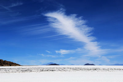 Scenic view of desert against blue sky