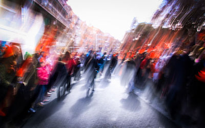 Crowd walking on illuminated street in city