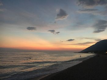 Scenic view of sea against dramatic sky during sunset