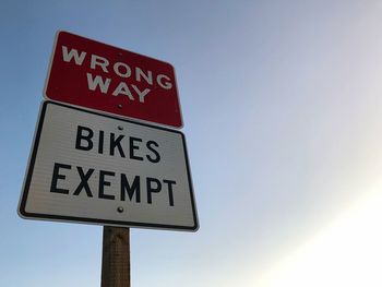 Low angle view of road sign against sky