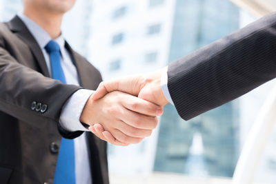 Close-up of business doing handshake outdoors