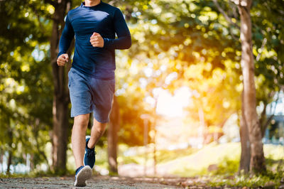 Low section of man running on road