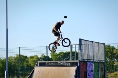 Man riding bicycle against clear sky