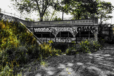 Text on bridge by tree against building