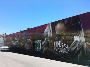 Graffiti on rusty train against clear blue sky