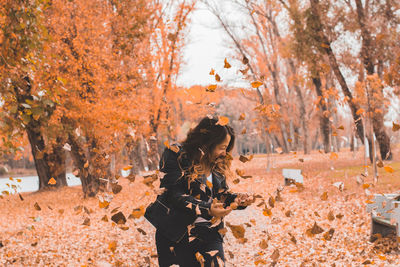 Beautiful girl among falling leaves - autumn portrait