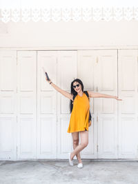 Portrait of woman standing against door