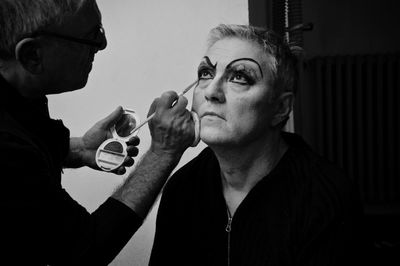 Close-up of man applying face paint to actor