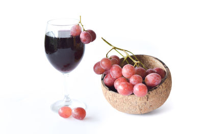 Close-up of grapes on table against white background