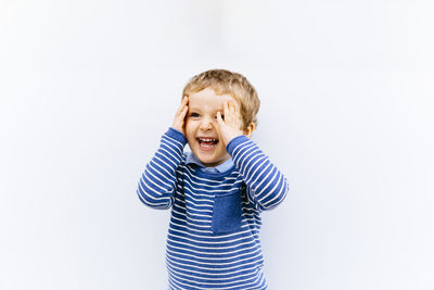 Portrait of happy boy against white background