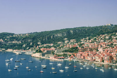 High angle view of cityscape by sea against clear sky