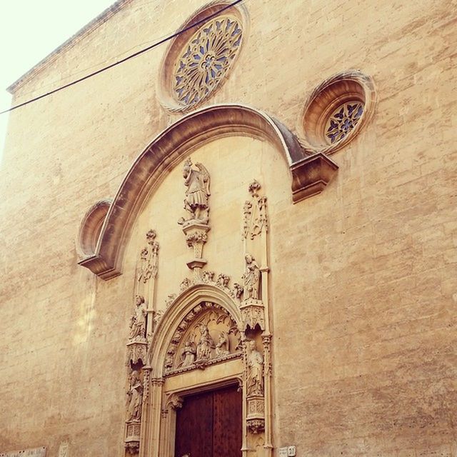 architecture, built structure, building exterior, low angle view, church, religion, arch, place of worship, spirituality, ornate, cross, facade, window, clock, cathedral, no people, history, day