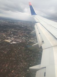 Cropped image of airplane flying over clouds