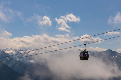 Low angle view of overhead cable car against sky