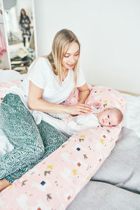 High angle view of mother with daughter on bed at home