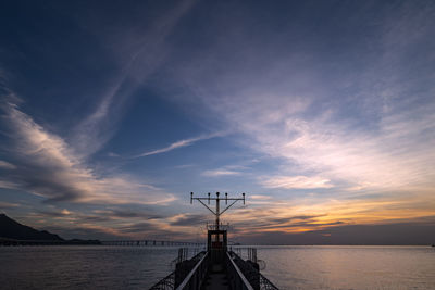 Silhouette ship on sea against sky during sunset