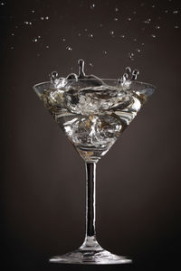 Close-up of cocktail splashing over gray background