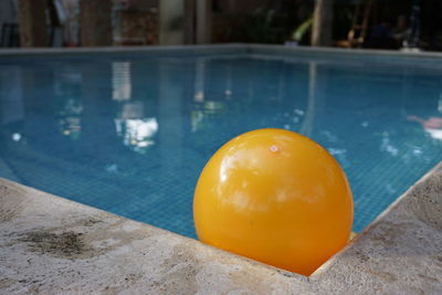 A yellow ball in the corner of a water pool