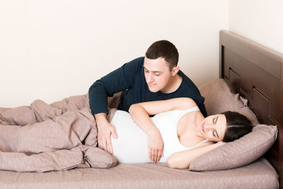 Young couple lying on bed at home